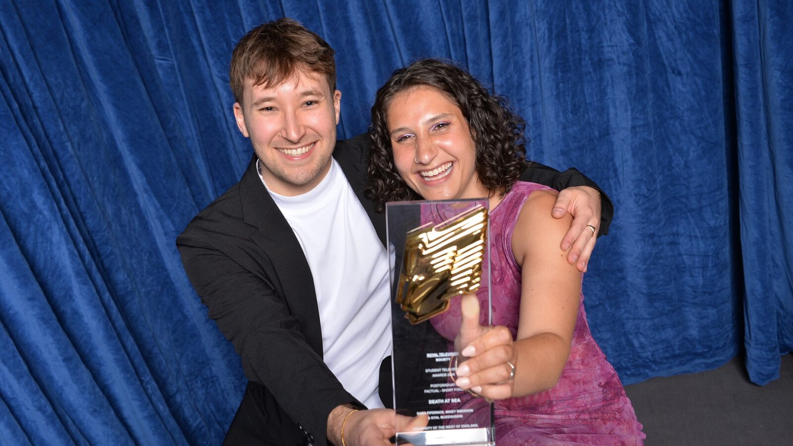 Two people hold RTS award