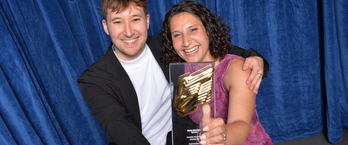 Two people hold RTS award